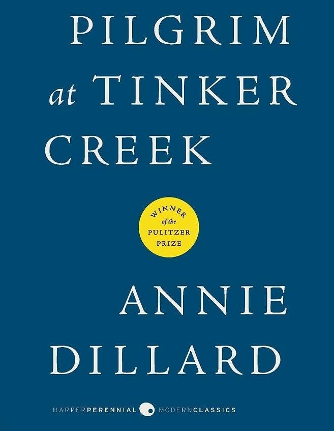 Cover of Annie Dillard's Pilgrim at Tinker Creek: white title lettering on a dark blue background with a yellow Pulitzer Prize seal, part of an Annie Dillard tribute.